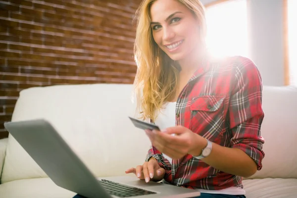 Hübsche Blondine mit Laptop auf der Couch — Stockfoto