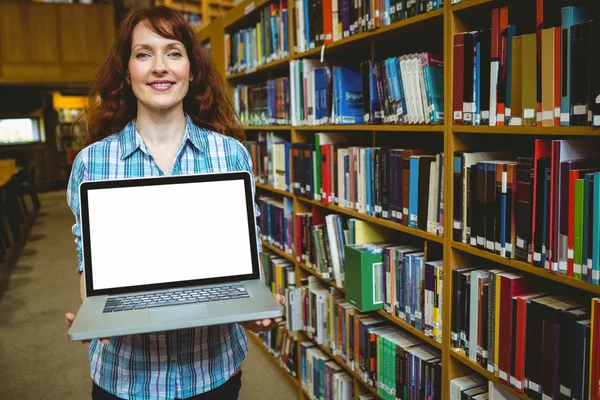 Volwassen student in bibliotheek met behulp van laptop — Stockfoto