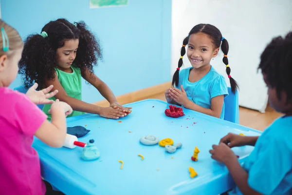 Smiling girls playing with modelling clay — Stock Photo, Image