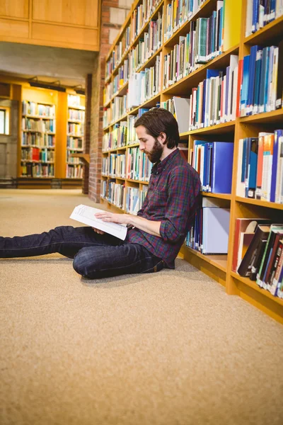 Uczniem czytanie książki w bibliotece na podłodze — Zdjęcie stockowe