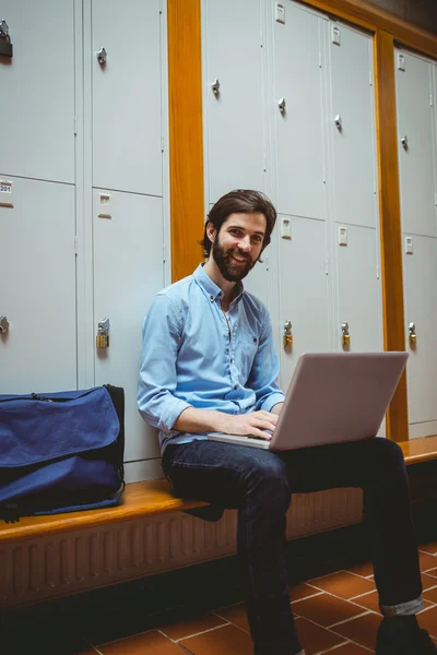 Étudiant hipster utilisant un ordinateur portable dans le couloir — Photo