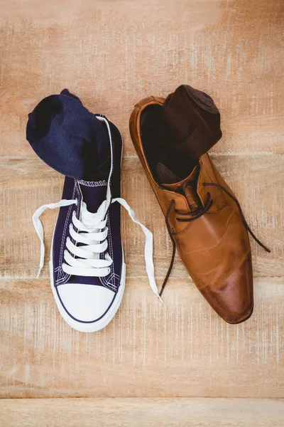 Twee verschillende schoenen op houten plank — Stockfoto