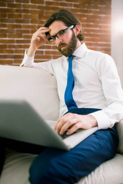 Businessman using laptop on the couch — Stock Photo, Image