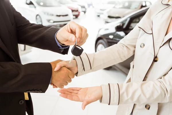 Salesman offering car key to customers — Stock Photo, Image