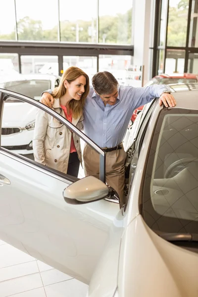 Lachende paar leunend op auto — Stockfoto