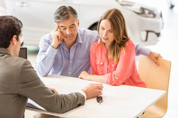 Couple souriant achetant une nouvelle voiture — Photo