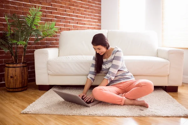 Aziatische vrouw met behulp van laptop op verdieping — Stockfoto