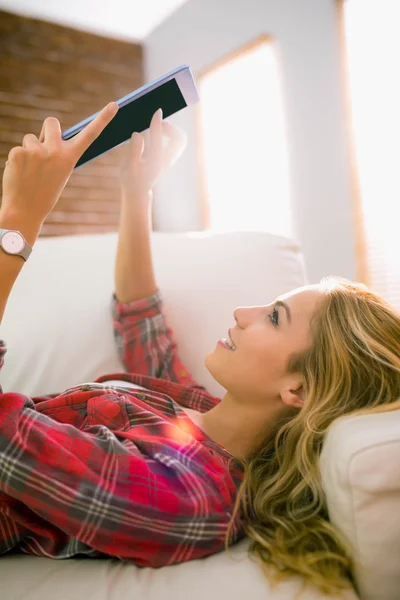 Pretty blonde using tablet on couch — Stock Photo, Image