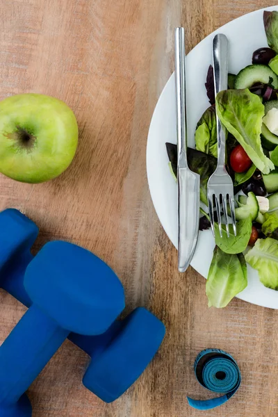 Salad, apple and dumbbells — Stock Photo, Image