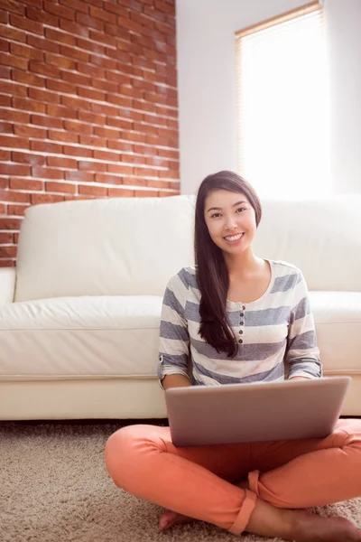 Asiatisk kvinna med laptop på golvet — Stockfoto