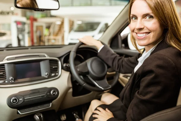 Glimlachende zakenvrouw aanbrengen in een auto — Stockfoto