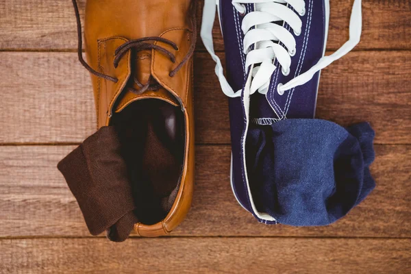 Twee verschillende schoenen op houten plank — Stockfoto