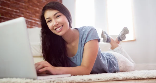 Asiatisk kvinna med laptop på golvet — Stockfoto
