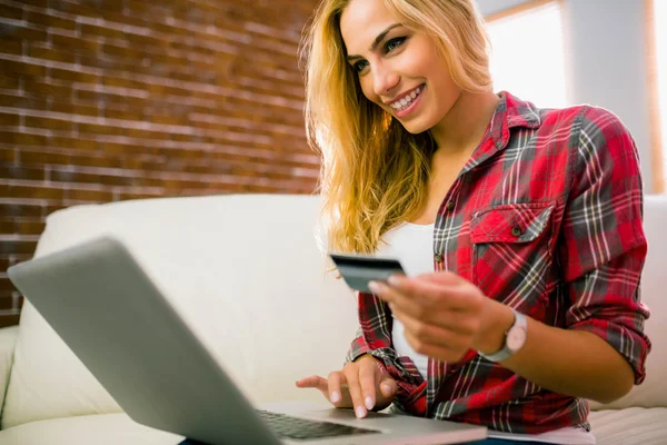 Hübsche Blondine mit Laptop auf der Couch — Stockfoto