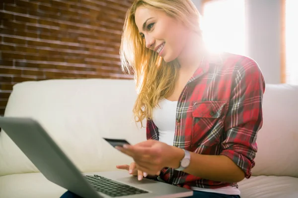 Pretty blonde using laptop on couch — Stock Photo, Image