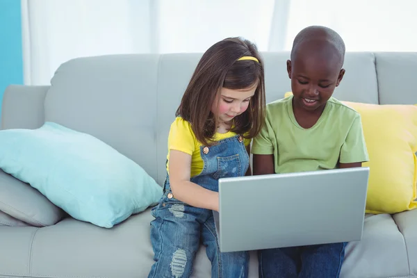 Mosolygó lány és egy fiú használ egy laptop — Stock Fotó