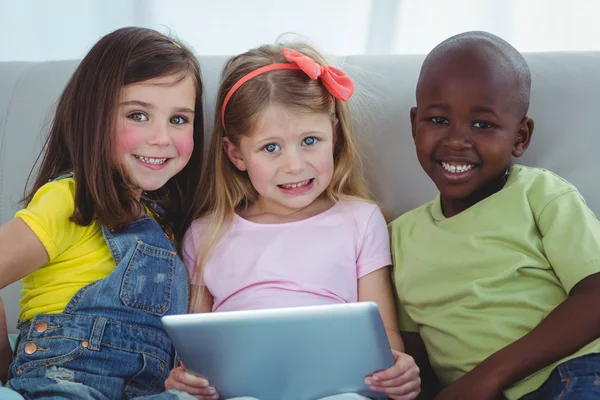 Enfants heureux assis avec une tablette — Photo