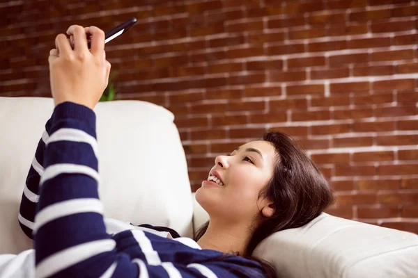 Asiática mulher no sofá tomando selfie — Fotografia de Stock