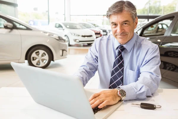 Lächelnder Verkäufer hinter seinem Schreibtisch — Stockfoto