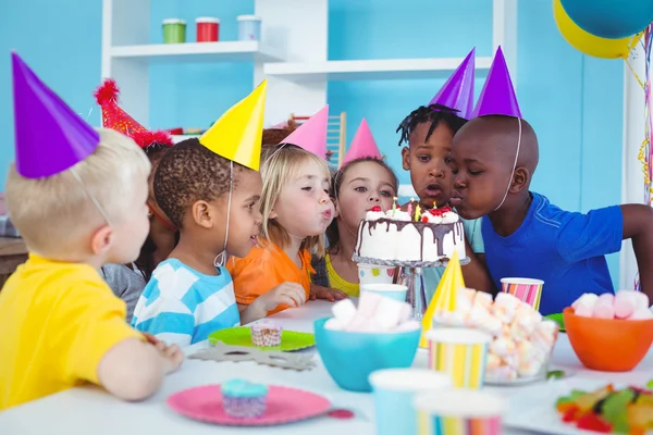 Excited kids enjoying a birthday party Stock Picture