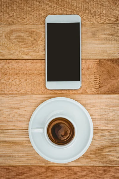 Café e um smartphone na mesa de madeira — Fotografia de Stock