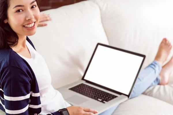 Mulher asiática no sofá usando laptop — Fotografia de Stock