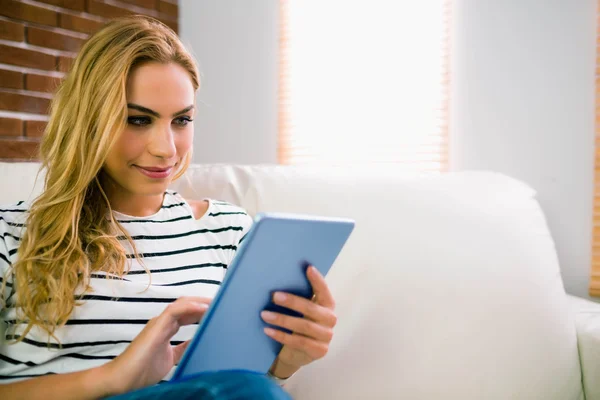 Hübsche Blondine mit Tablet auf Couch — Stockfoto