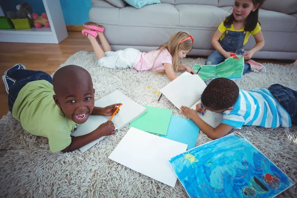 Des enfants souriants dessinent des images sur papier — Photo