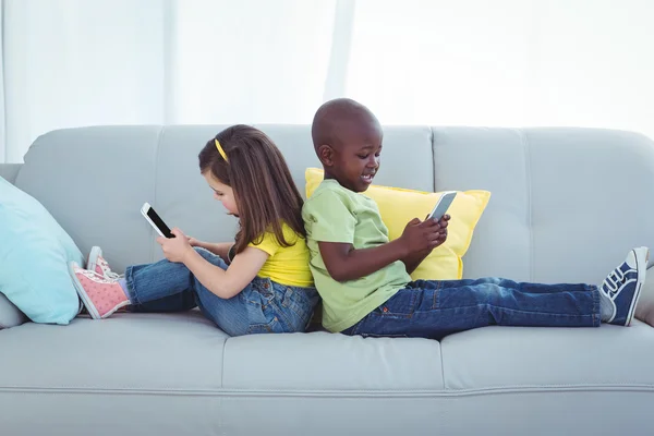 Lächelnde Mädchen und Jungen mit Mobiltelefonen — Stockfoto