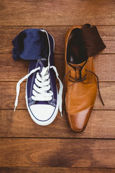 Two different shoes on wood plank — Stock Photo, Image