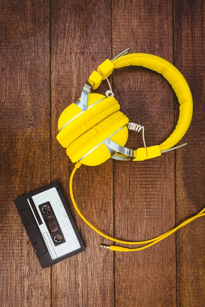 Vieja cinta y auriculares en escritorio de madera — Foto de Stock