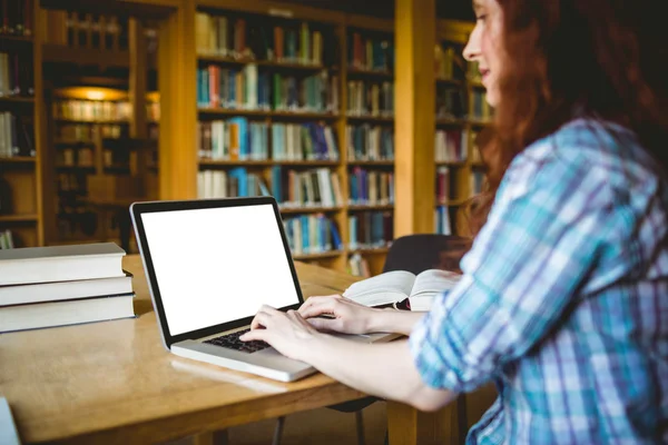 Estudante maduro estudando na biblioteca com laptop — Fotografia de Stock