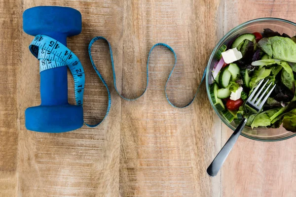 Salad, tape  and dumbbell — Stock Photo, Image