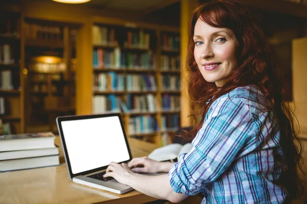 Mogen student som studerar i biblioteket med laptop — Stockfoto