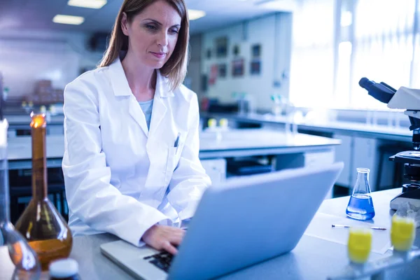 Científico trabajando con un ordenador portátil en laboratorio — Foto de Stock