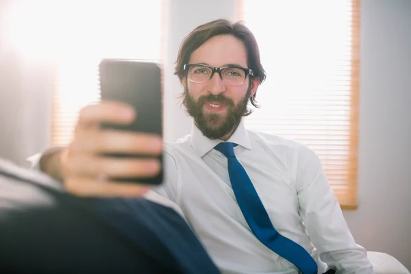 Uomo d'affari che invia un messaggio sul divano — Foto Stock