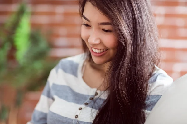 ソファの上の笑顔のアジア女性 — ストック写真