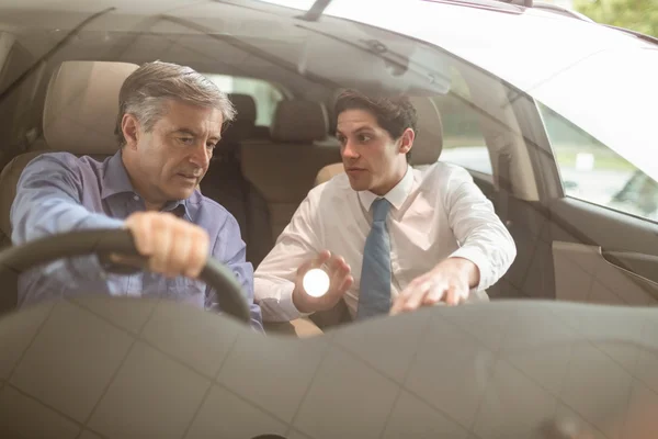 Biznesmen wskazując wnętrza samochodu — Zdjęcie stockowe