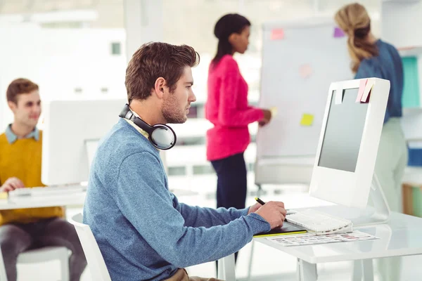 Graphiste portant des écouteurs au bureau — Photo