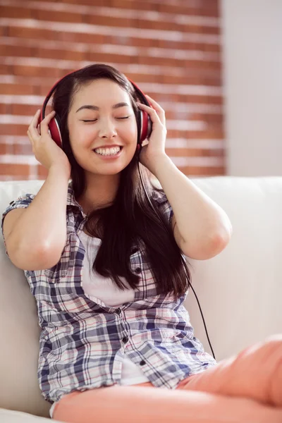 Mujer asiática en el sofá escuchando música —  Fotos de Stock