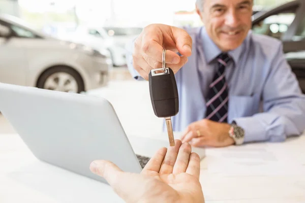 Vendedor segurando chave do carro do cliente — Fotografia de Stock