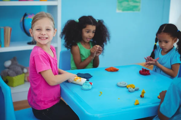 Lächelnde Mädchen spielen mit Modelliermasse — Stockfoto