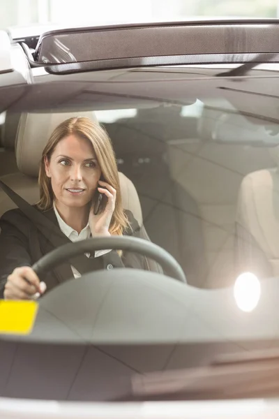 Affärskvinna med ett telefonsamtal som sitter i bilen — Stockfoto