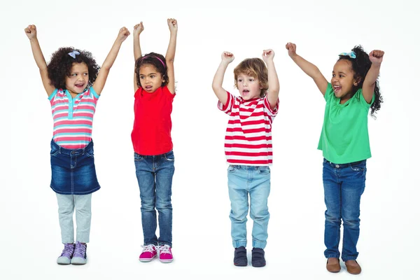 Quattro bambini in piedi con le braccia alzate in aria — Foto Stock