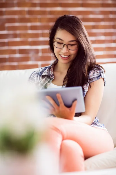 Asian woman on the couch using tablet — Stock Photo, Image