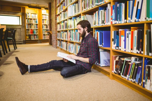 Uczniem czytanie książki w bibliotece na podłodze — Zdjęcie stockowe