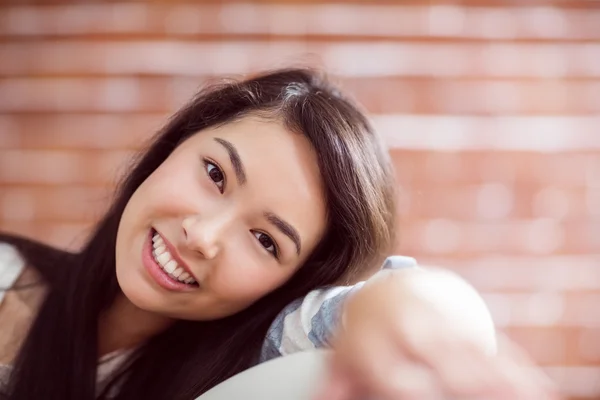 Sorridente donna asiatica sul divano — Foto Stock