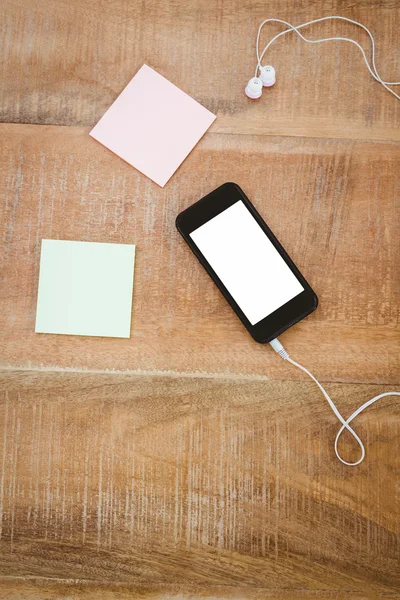 Publique y teléfono inteligente negro con auriculares blancos — Foto de Stock