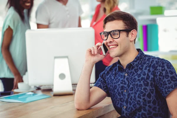 Sonriente empresario creativo trabajando cerca de compañeros de trabajo — Foto de Stock