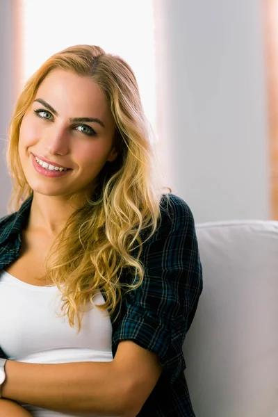 Hübsche Blondine entspannt sich auf der Couch — Stockfoto